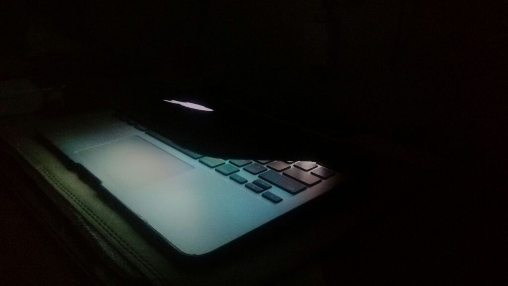 a laptop computer lit up in the dark