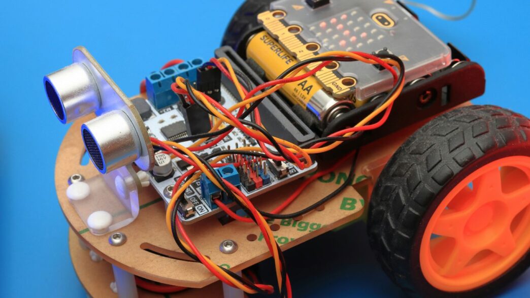 a small robot car with wheels and wires attached to it