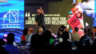 Speaker presents book to audience on stage