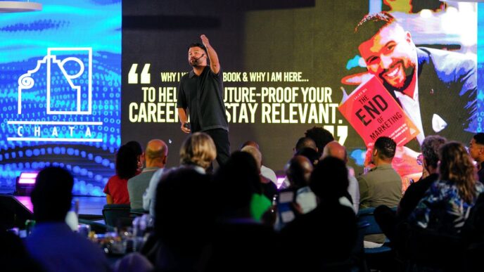 Speaker presents book to audience on stage