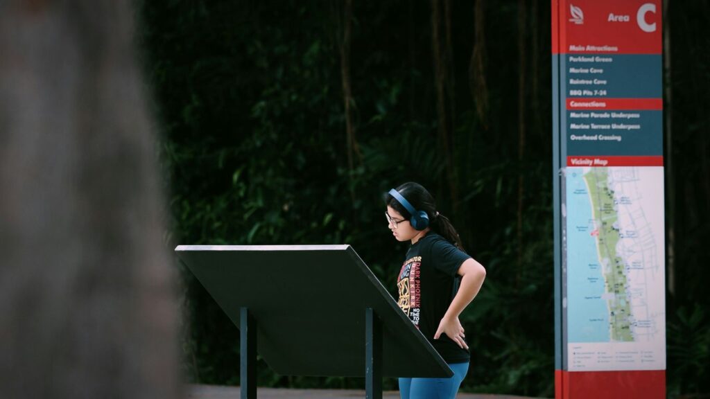 A woman wearing headphones looks at a map.