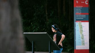 A woman wearing headphones looks at a map.