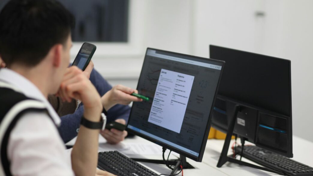 A group of people sitting at a table with computers