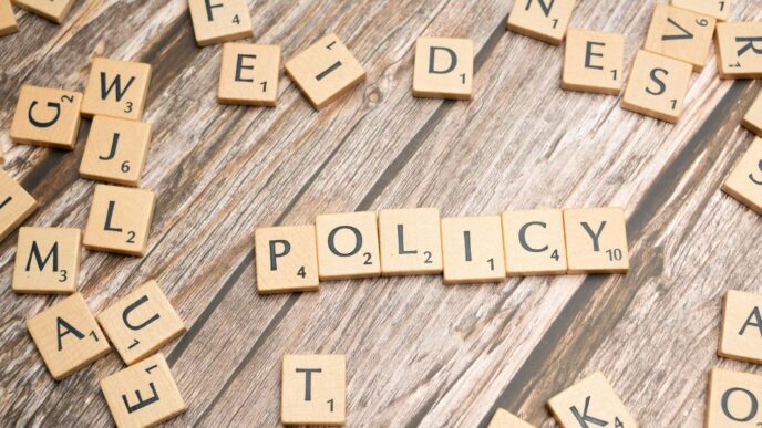 scrabble tiles spelling policy on a wooden table