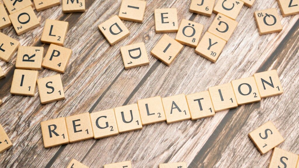 scrabble tiles spelling out the word regulation on a wooden surface