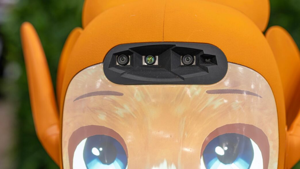 Close-up of an orange robot's face with blue eyes