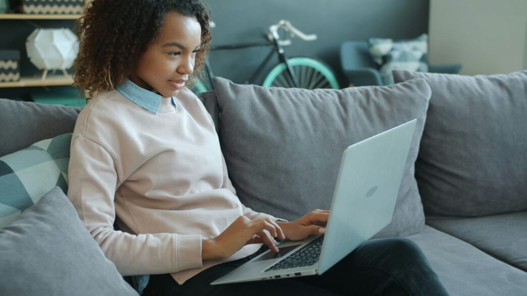 Woman working on a laptop on a couch