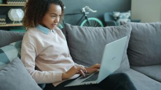Woman working on a laptop on a couch