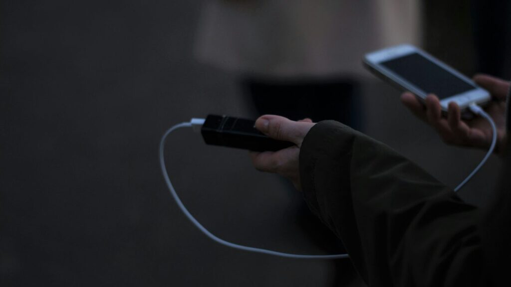 a person holding a cell phone and a charger