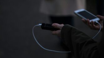a person holding a cell phone and a charger