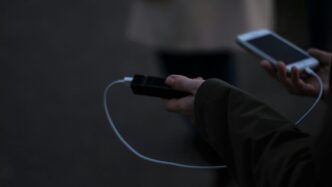 a person holding a cell phone and a charger