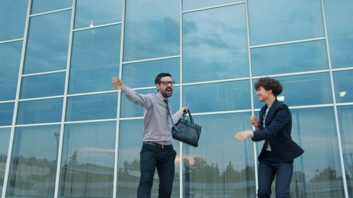 Two business people celebrating outside modern office building