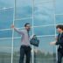 Two business people celebrating outside modern office building
