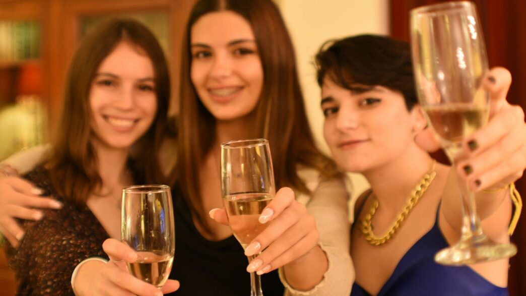 a group of women holding up wine glasses