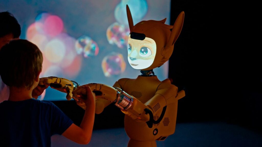 Child and robot interacting with projected bubbles