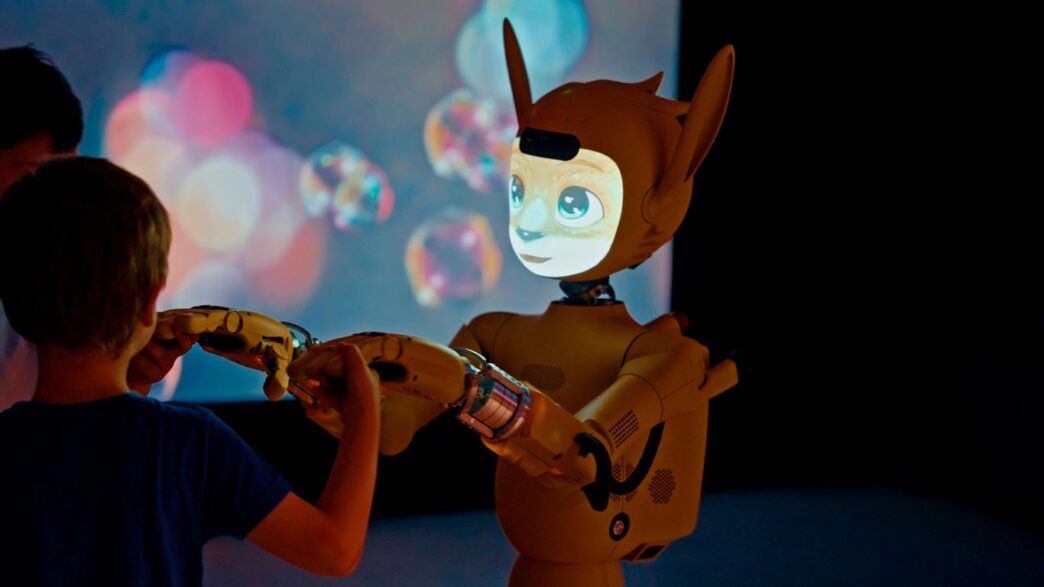 Child and robot interacting with projected bubbles