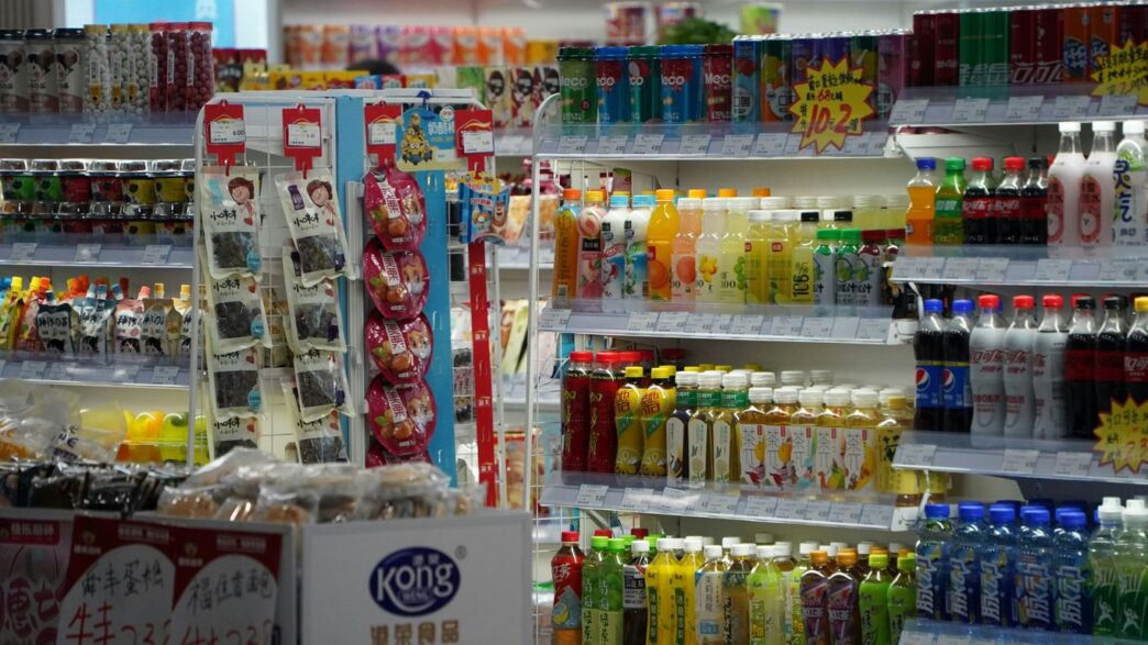 Shelves stocked with drinks and snacks in a store.