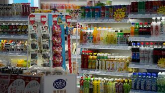 Shelves stocked with drinks and snacks in a store.