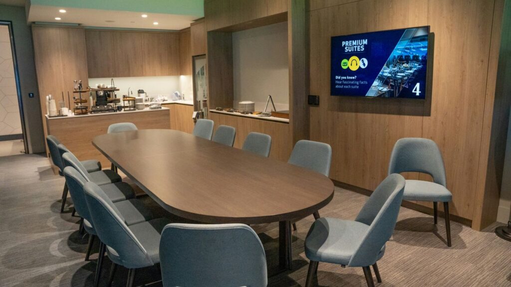 a conference room with a large wooden table and blue chairs