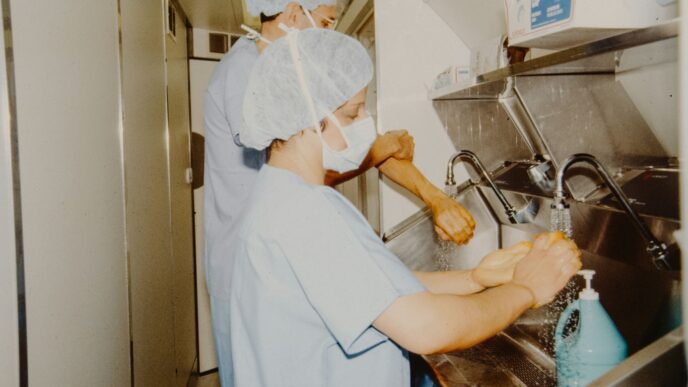 Two medical professionals scrubbing hands before surgery.