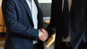 Two business partners shaking hands in agreement.