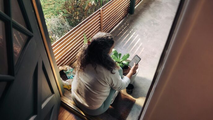 Woman sitting on balcony with smartphone