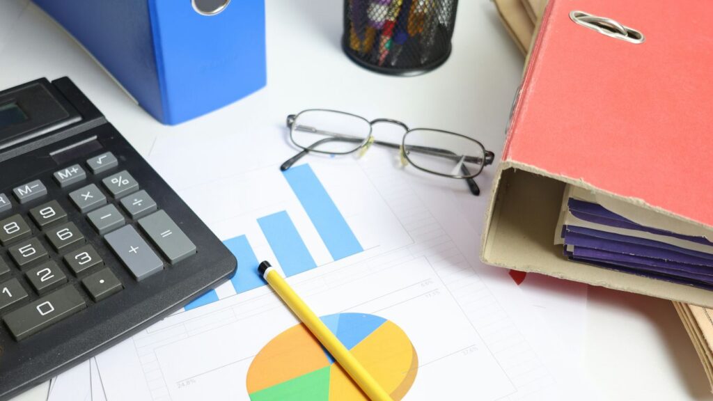 Desk with calculator, charts, and binders