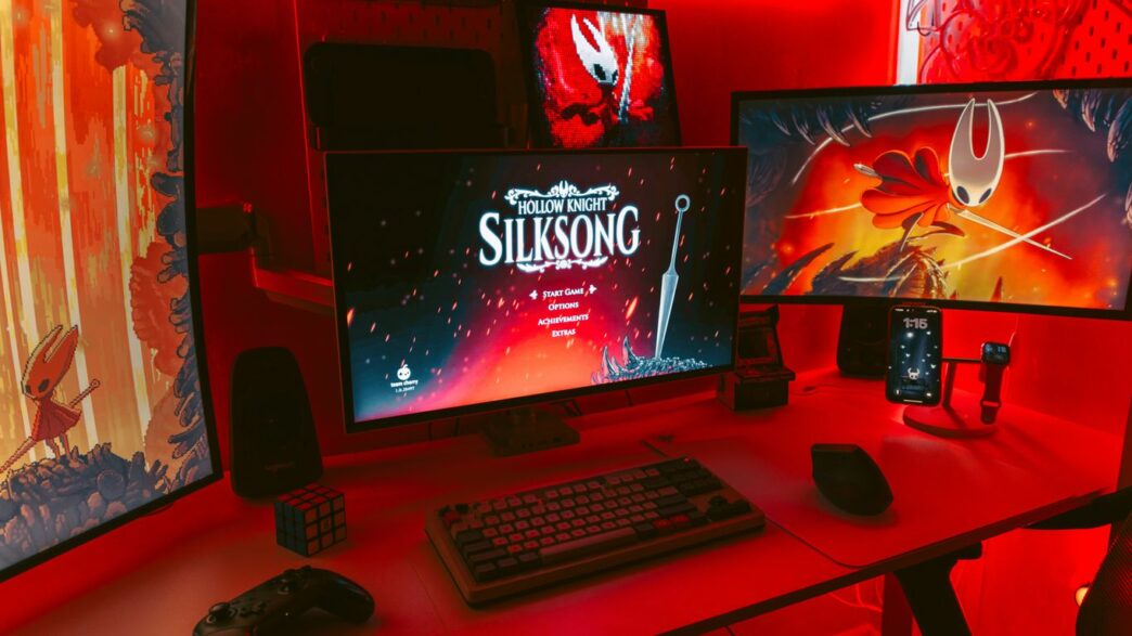 Gaming setup with multiple monitors displaying game art.