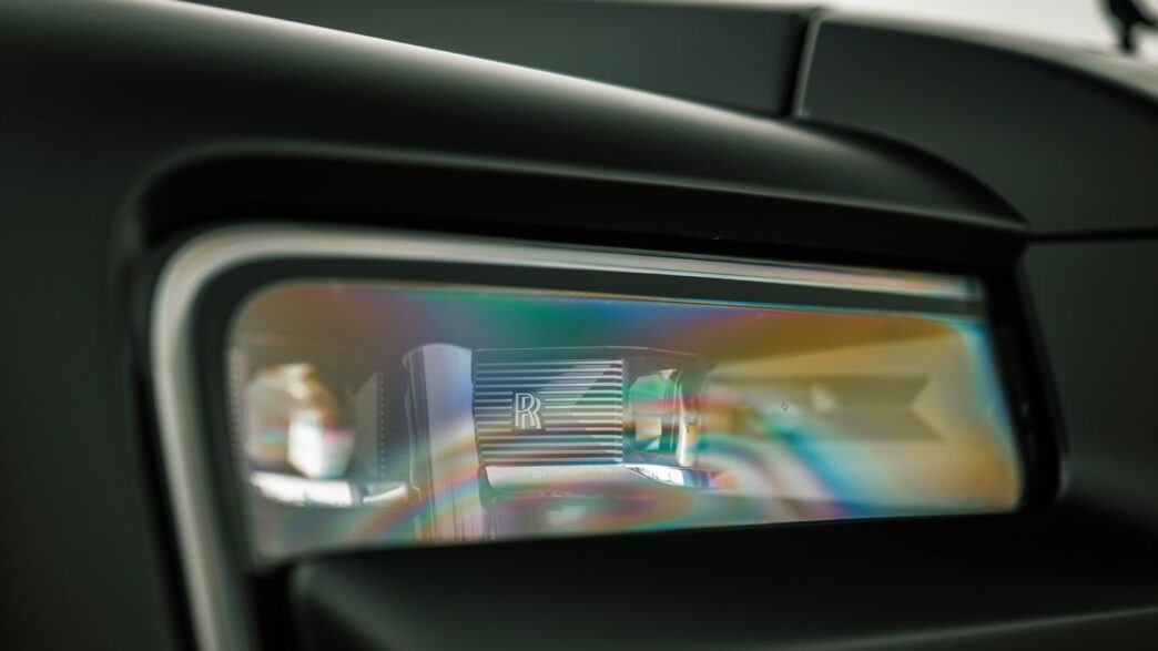 Close-up of a car's modern headlight reflecting colors