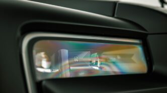 Close-up of a car's modern headlight reflecting colors