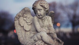 Stone angel statue in a cemetery at dusk