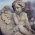 Stone angel statue in a cemetery at dusk