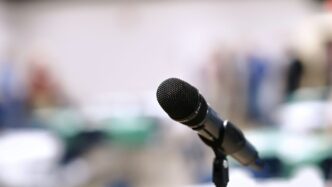 A microphone stands on a stand in an empty room.