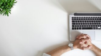 person wearing watch near a laptop