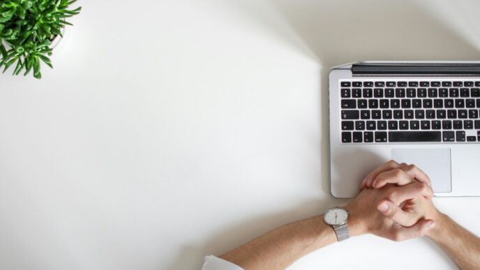 person wearing watch near a laptop