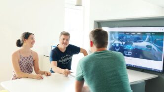 3 men and 2 women sitting at table