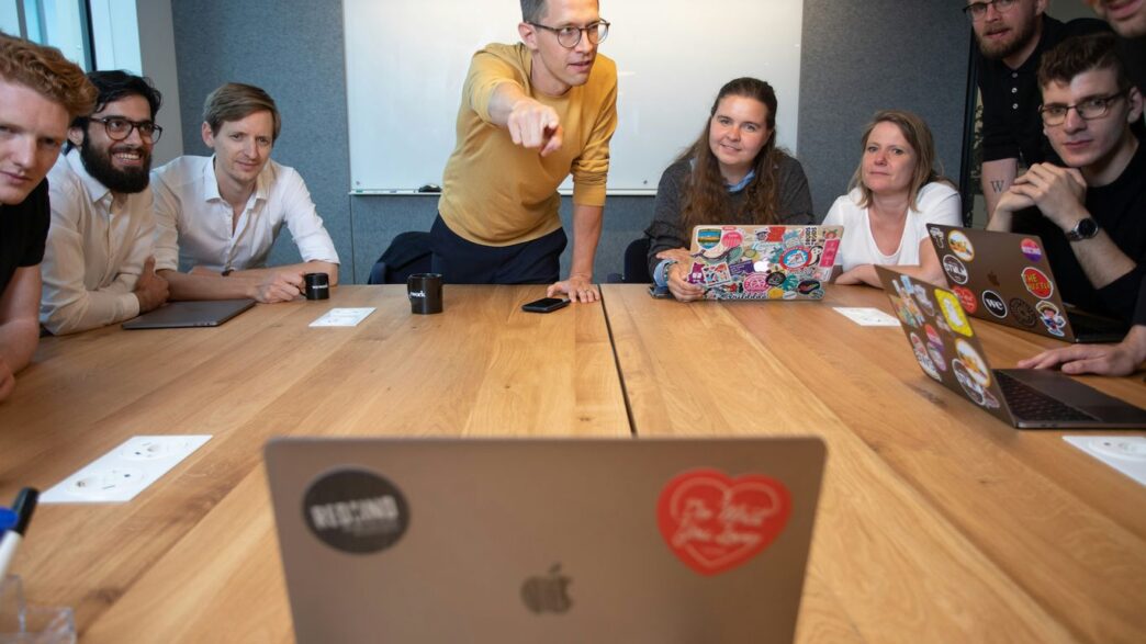a group of people sitting around a wooden table