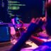 Person coding on multiple screens at night.