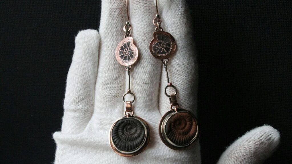 a hand with a pair of earrings on it