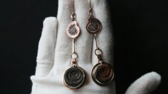 a hand with a pair of earrings on it