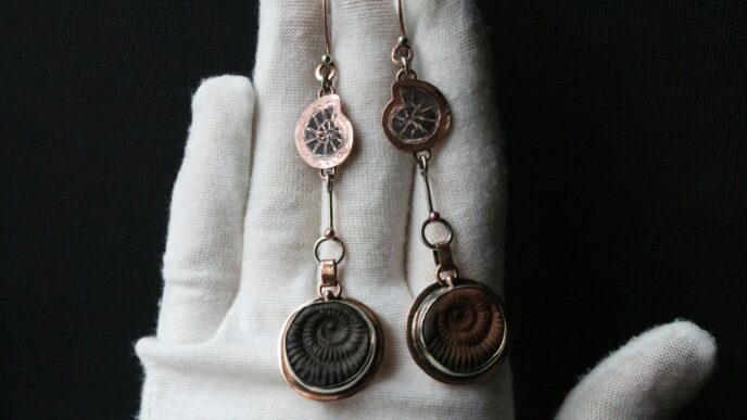 a hand with a pair of earrings on it