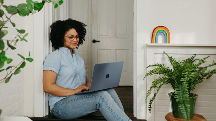a woman sitting on the floor using a laptop