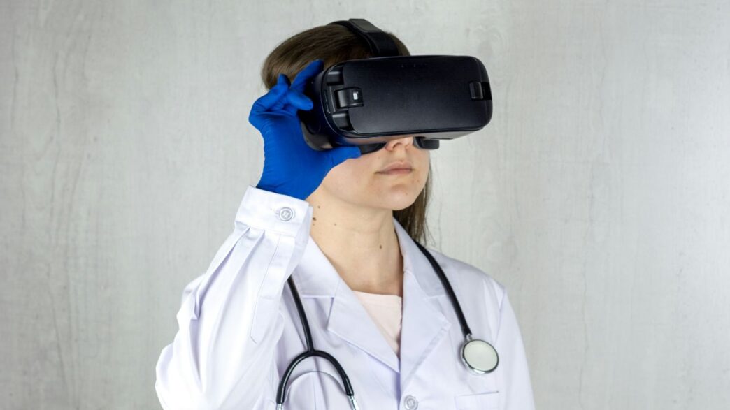 a woman in a white coat and blue gloves is wearing a virtual headset