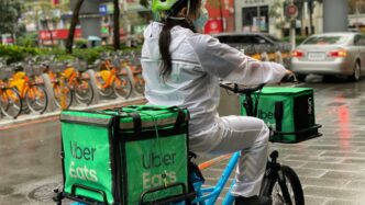 a person riding a bike with a cooler strapped to the back