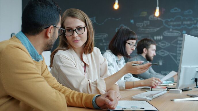 Colleagues collaborating at a modern office desk.