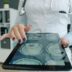 Doctor shows brain scan on tablet in office