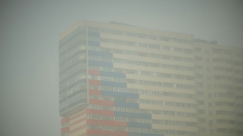 A tall building with a red white and blue flag on it