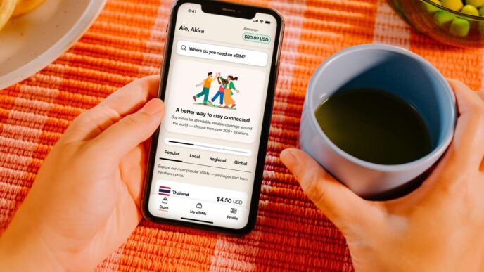 Hands holding smartphone with app, coffee cup, and food.