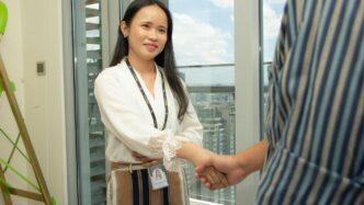 smiling woman in white long-sleeved blouse shaking hands