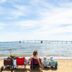 a woman sitting in a chair on the beach